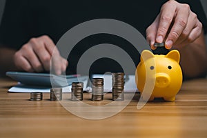 Businessman holding a coin in a piggy bank. money growth and saving money.