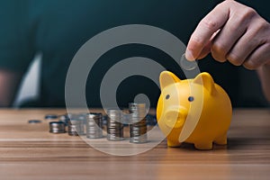 Businessman holding a coin in a piggy bank. money growth and saving money.