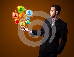 businessman holding colorful social network icons in his hand