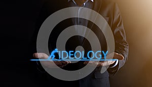 Businessman holding a concept in his hands.The silhouette of man pushes the word IDEOLOGY.business economy concept