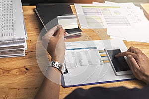 Businessman holding credit card and using smartphone. Making payment while online shopping. E-commerce and modern technology