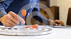 Businessman holding a darts aiming at the target center