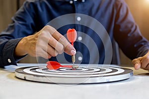 Businessman holding a darts aiming at the target center