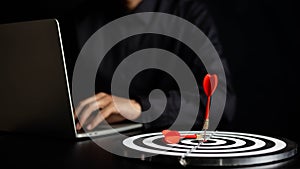 Businessman holding a darts aiming at the target center business goal concept