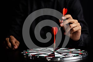 Businessman holding a darts aiming at the target center business goal concept