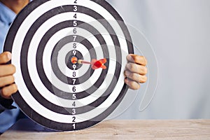 Businessman holding a darts aiming at the target center business goal concept - business targeting, aiming, focus concept,metaphor