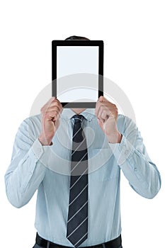 Businessman holding digital tablet in front of his face