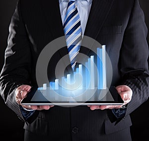 Businessman holding digital tablet with graph