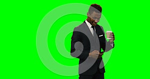 Businessman holding disposable coffee cup and using mobile phone