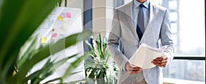 The businessman holding documents in a modern office setting. AI generated image