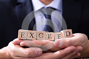 Businessman Holding Exceed Expectations Word