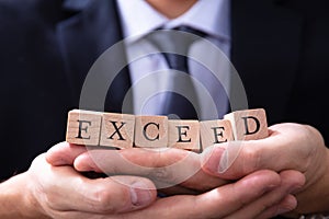 Businessman Holding Exceed Expectations Word photo