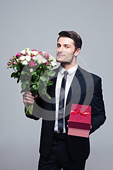 Businessman holding flowers and gift box