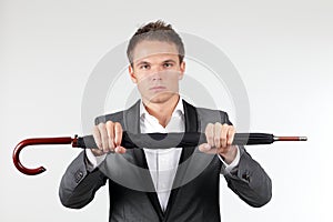 Businessman holding a folded umbrella