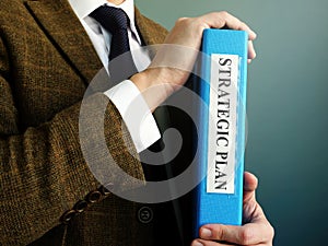 Businessman is holding folder with Strategic Plan