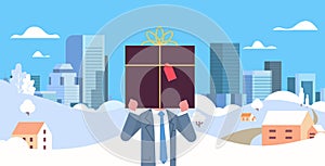 Businessman holding gift box in front of face christmas new year winter holidays celebration concept snowfall cityscape