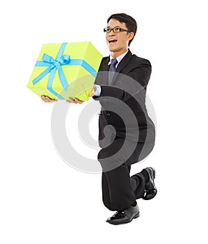 Businessman holding a gift box and kneel down .