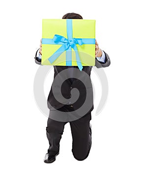Businessman holding a gift box and kneel down . photo
