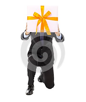 Businessman holding a gift box and kneel. isolated on white