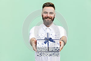 Businessman holding gift box and looking at camera and toothy smile.