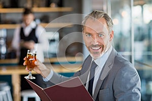 Businessman holding glass of beer and menu