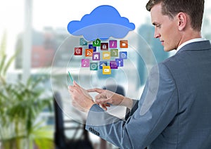 Businessman holding glass tablet with apps icons in bright office