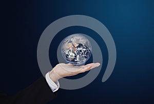 Businessman holding globe, on blue background. Global business concept. Element of this image are furnished by NASA