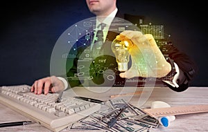 Businessman holding glowing glass light bulb