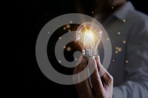 Businessman holding a glowing light bulb showing having a new id