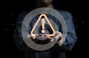 Businessman holding glowing red triangle caution warning exclamation sign for notification error and maintenance concept