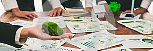 Businessman holding green EV car model mock in electric car company.Trailblazing