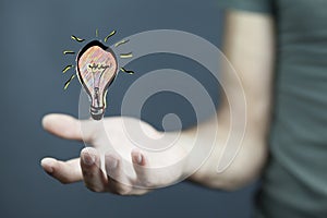 Businessman holding hand drawn lightbulb in his hand