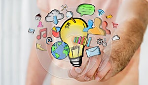 Businessman holding hand drawn lightbulb and multimedia icons