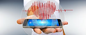 Businessman holding heart beat sketch over mobile phone