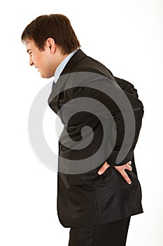 Businessman holding his hand at his aching back