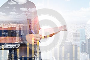 Businessman is holding his notes and pen. Double exposure of financial chart and New York skyline background. Concept of financial