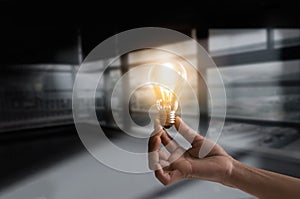 Businessman holding illuminated light bulb concept for idea, innovation and creativity inspiration concept ideas