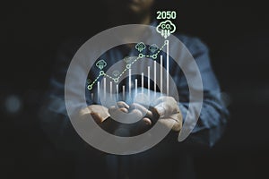 Businessman holding increasing graph with CO2 reducing icon for decrease CO2 , carbon footprint and carbon credit to limit global