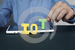 Businessman holding IOT word.