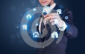 Businessman holding keys with houses around