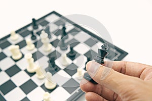 Businessman holding a King Chess is placed on Chess board.using as background business concept and Strategy concept with copy spac