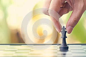 Businessman holding a King Chess is placed on a chessboard.using as background business concept and Strategy concept with copy spa