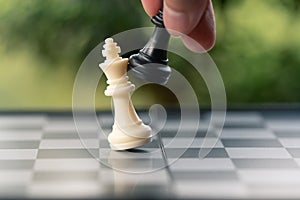 Businessman holding a King Chess is placed on a chessboard.using as background business concept and Strategy concept with copy sp