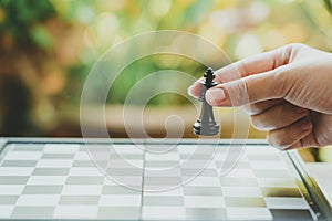 Businessman holding a King Chess is placed on a chessboard.using as background business concept and Strategy concept with copy