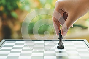 Businessman holding a King Chess is placed on a chessboard.using as background business concept and Strategy concept with copy