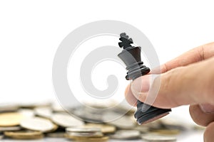 Businessman holding a King Chess is placed on a pile of coins. using as background business concept and Strategy concept photo