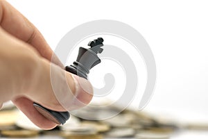 Businessman holding a King Chess is placed on a pile of coins.using as background business concept and Strategy concept photo