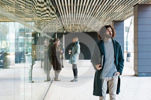 Businessman holding a laptop while leaving the office building.