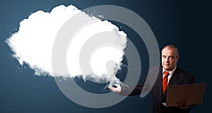 Businessman holding a laptop and presenting abstract cloud copy