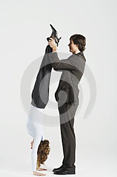 Businessman Holding Legs Of Female Colleague Standing On Hands